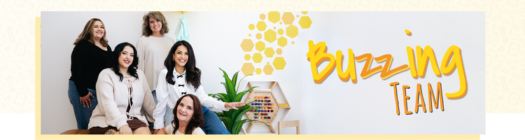 Group of women standing together with a 'Buzzing Team' banner in the background