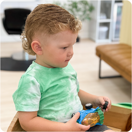 Child playing with a toy car in a living room setting
