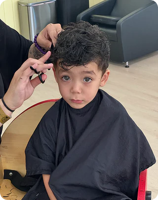 Child getting a haircut in a salon setting