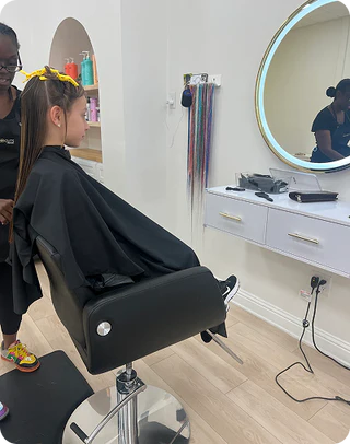 Person getting a haircut in a salon with a mirror and hair products in the background.