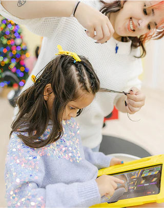Child using a tablet with an adult in a casual setting