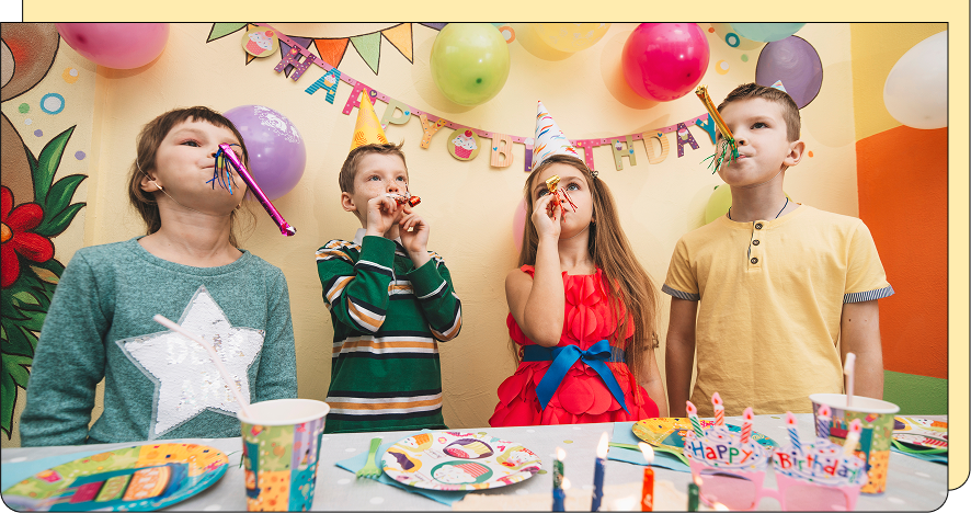Children at a birthday party with balloons and decorations.