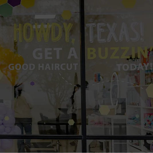 Hair salon interior with decorative elements and text on glass doors.